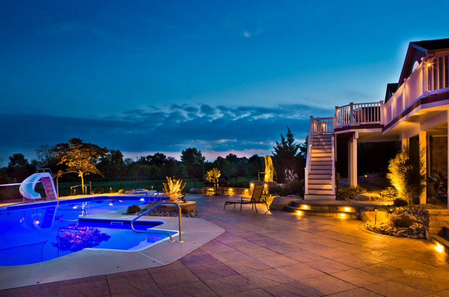 a backyard area with pool and outdoor lighting