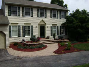 newly installed paver patio, steps, stone wall, and mulch beds