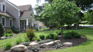 well maintained beds and landscape material in front of a large home