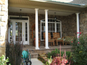 a covered front porch that's well landscaped in front
