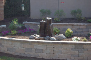 stone retaining wall with 3 tiered water feature