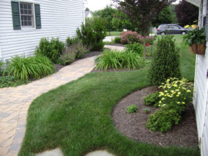 well maintained lawn, landscape and hardscape walkway between homes