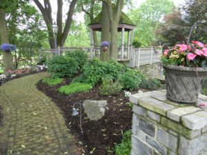 a small mulch bed with various shrubs and trees planted in it.