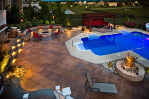 attractive outdoor pool area with outdoor seating area, a fire pit, and landscape lighting mixed in