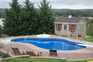 a backyard with a pool, nice hardscaped pavers, a pool house, and spa