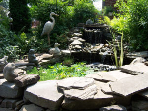 stone water feature with decorative frogs and other features